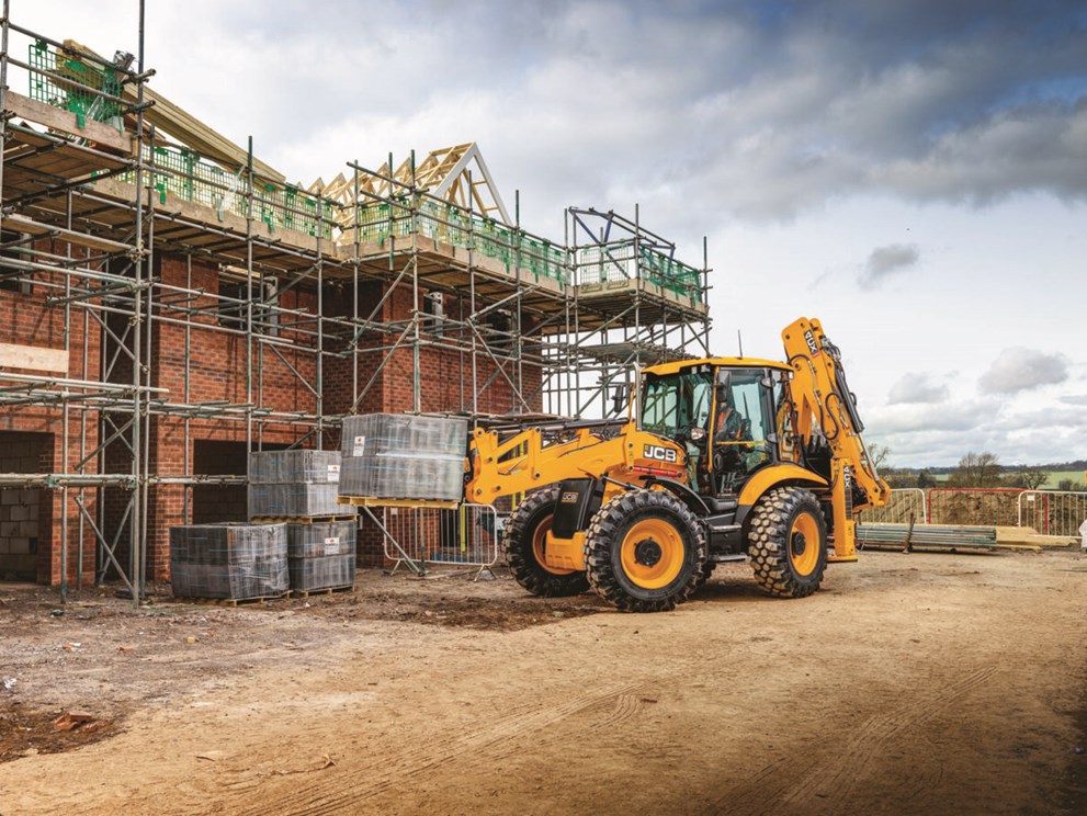 4CX Backhoe loader on a house building site lifting materials on forks
